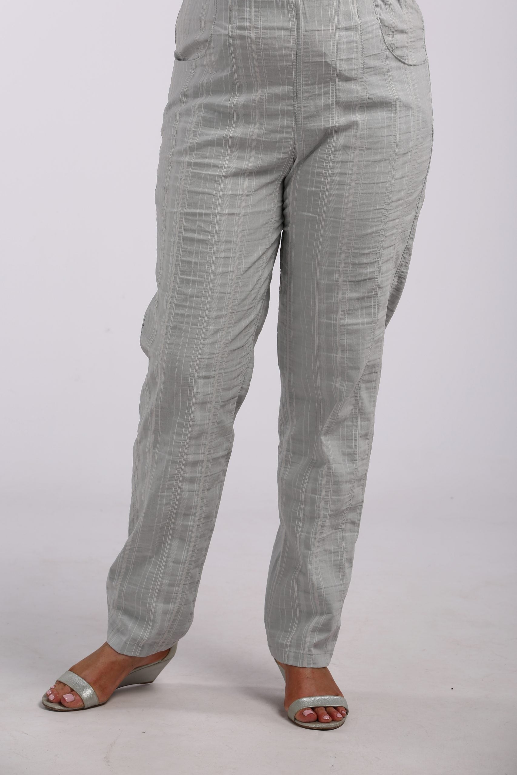 Woman wearing summer cool trousers in silver grey by K J Brand