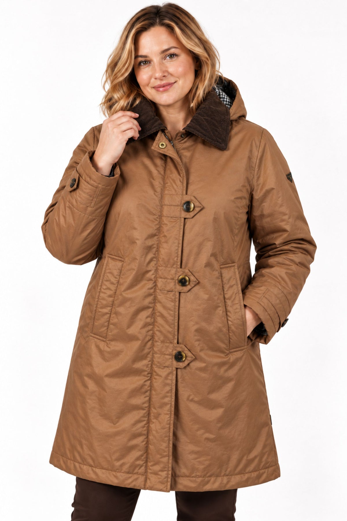 A woman wearing a mid-length brown waxed cotton parka with a dark brown faux-fur collar, shown against a plain white background.