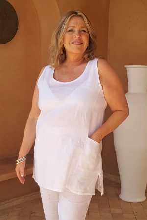 Woman is wearing white linen vest by Kasbah Clothing