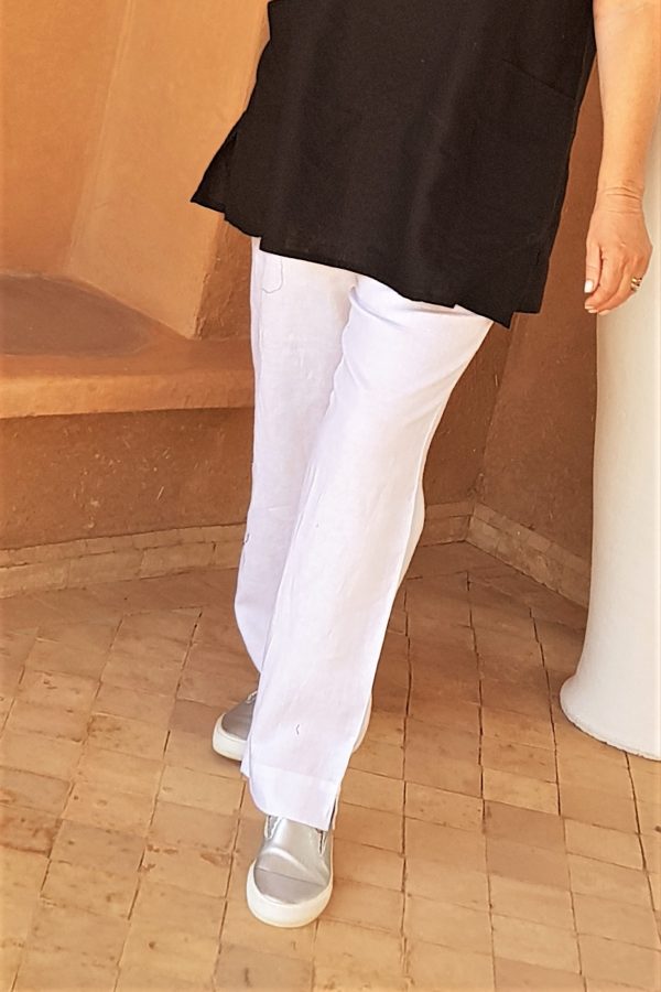 Woman is wearing white linen trousers by Kasbah CLothing