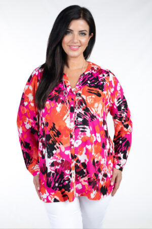 Model is wearing VIa Appia blotch print shirt in greens pinks and oranges for plus sizes